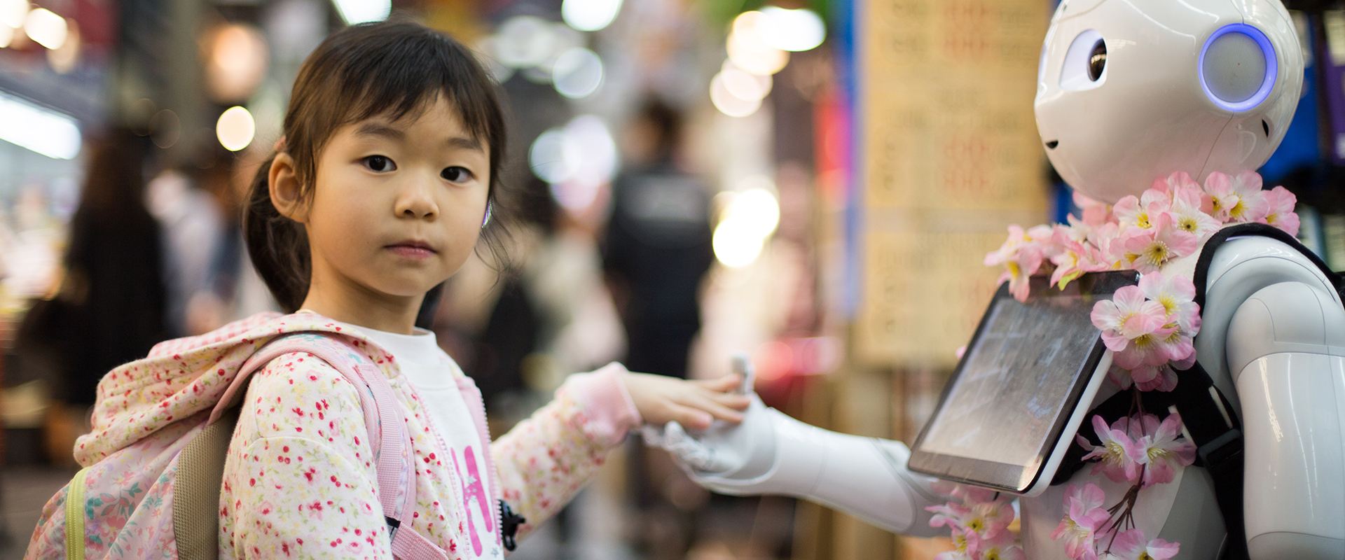 Girl shaking hand with a robot human
